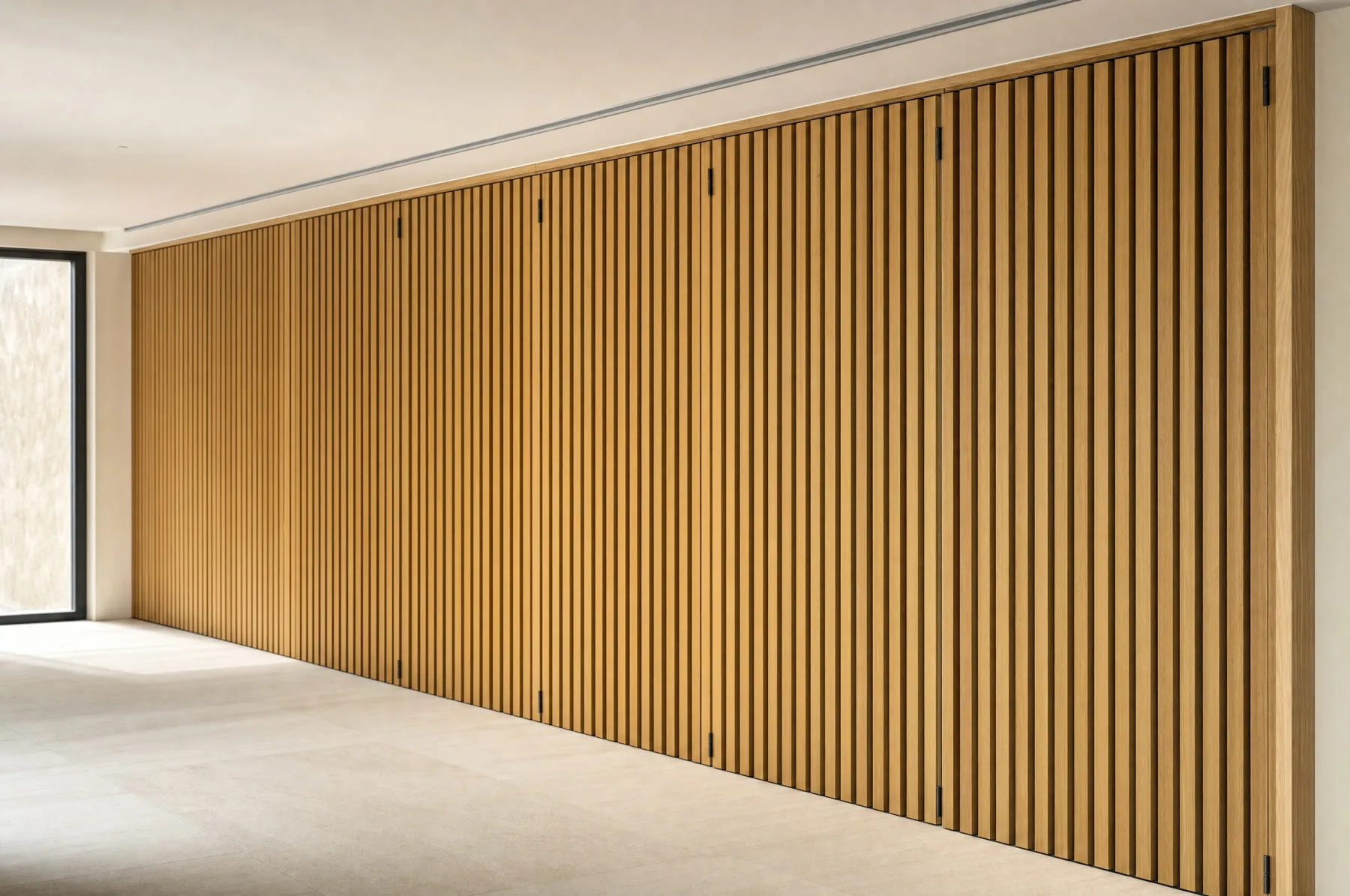 Tabique plegable de listones verticales de roble cerrado a lo ancho de una sala