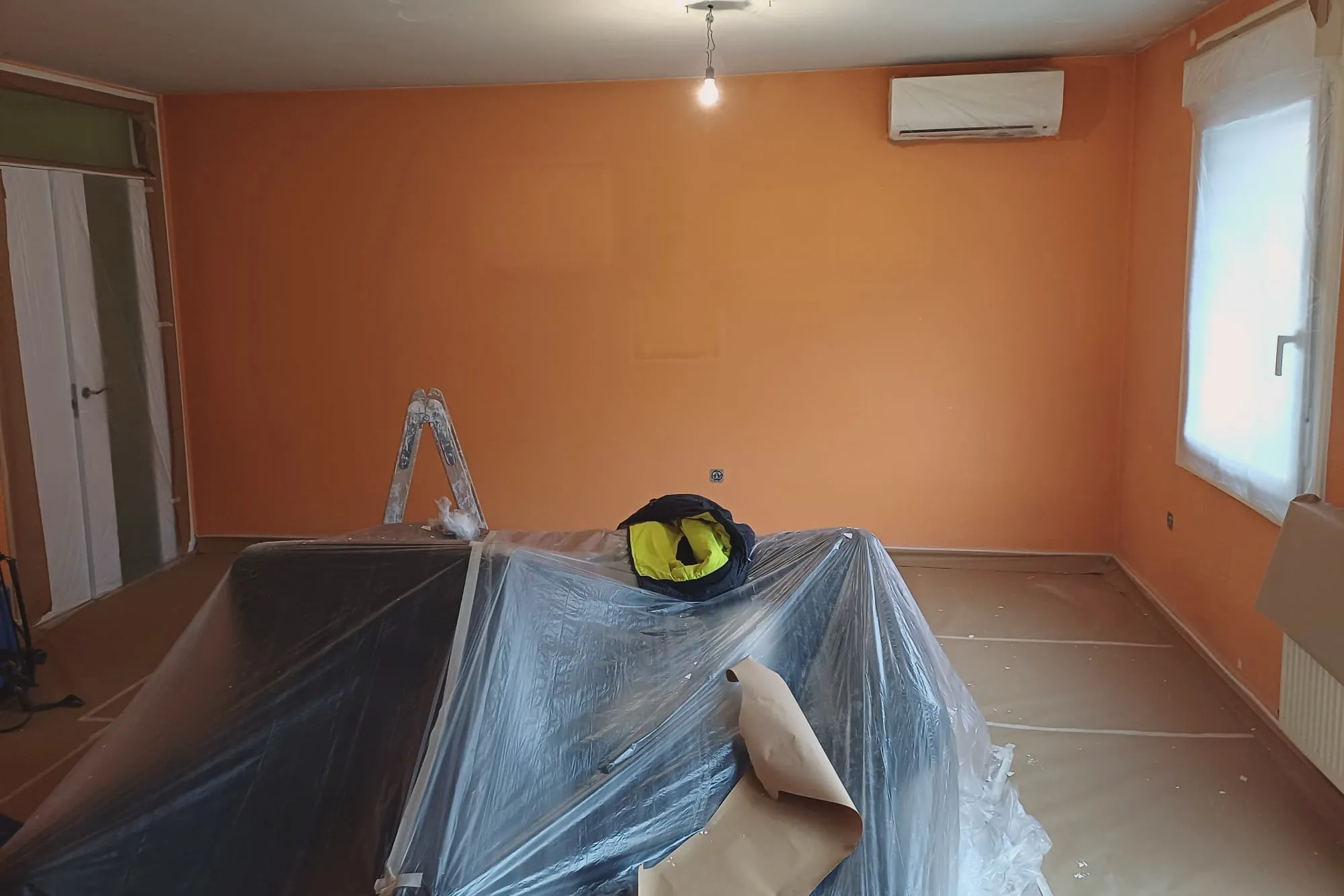 Habitación pintada en naranja con el techo terminado en blanco